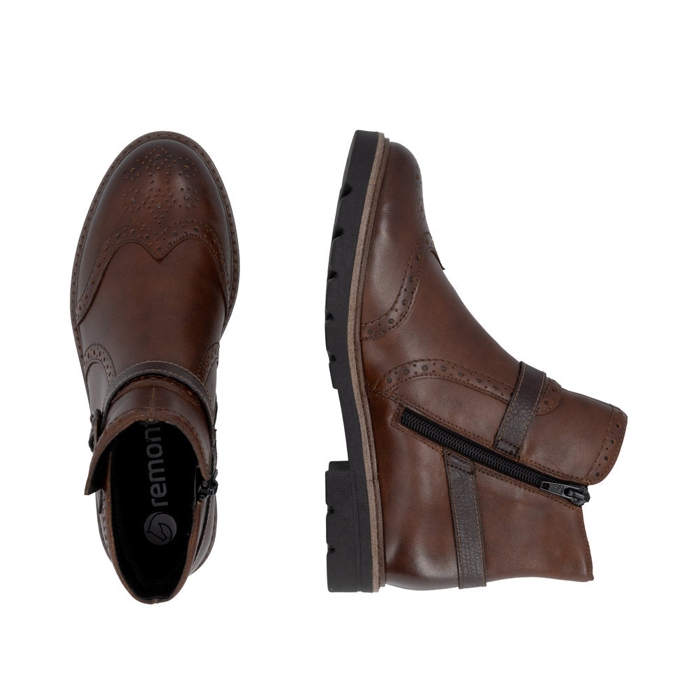 Pair of brown leather boots with zippers on a white background