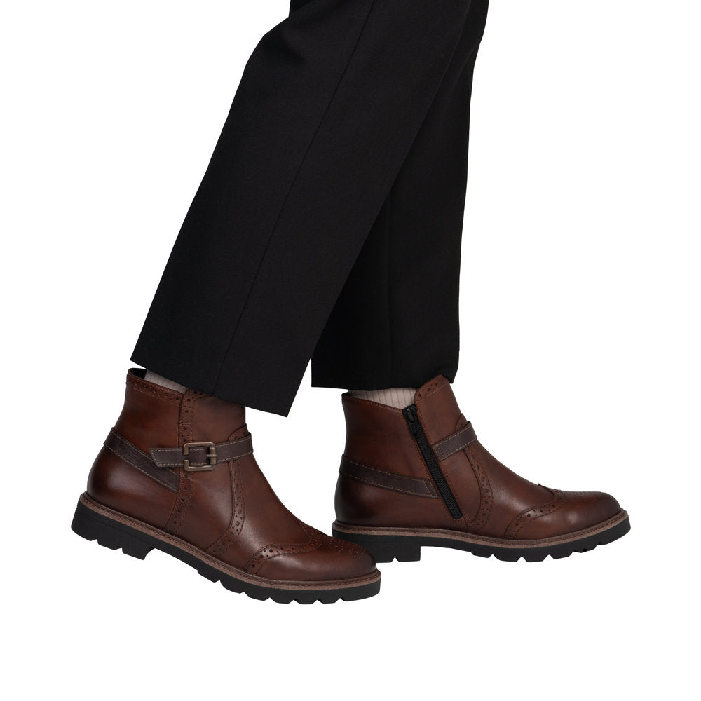 Brown leather boots with a buckle on a white background