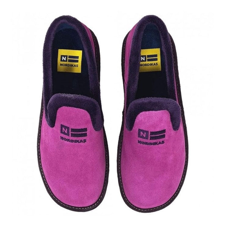 Pair of pink slippers with black soles on a white background