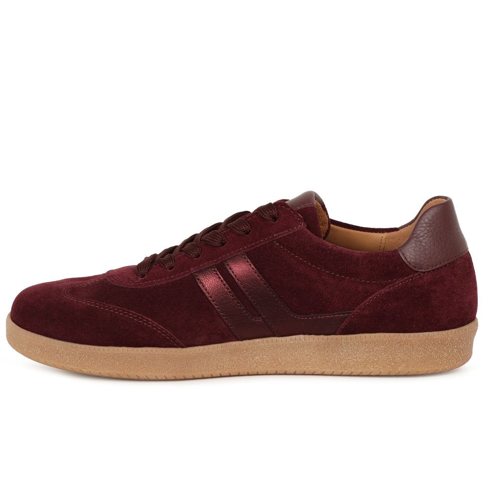 A low-top suede sneaker in deep burgundy with matching burgundy laces and a gum-colored sole, shown from a side profile on a white background.